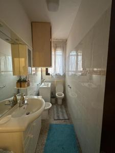 y baño con lavabo, aseo y espejo. en Rosa apartment, en Venecia