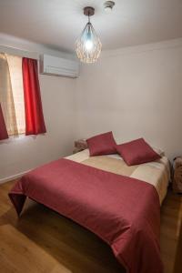 a bedroom with a bed with a red blanket at Casa das Ruas (Xisto Sentido®) 