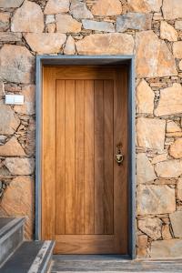 a wooden door in a stone wall at Casa das Ruas (Xisto Sentido®) 