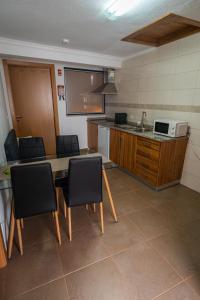 a kitchen with a table and chairs and a microwave at Casa das Ruas (Xisto Sentido®) 