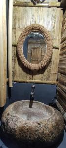 y baño con lavabo de piedra y espejo. en Fab - Bamboo Hut with Open Shower, en Munnar