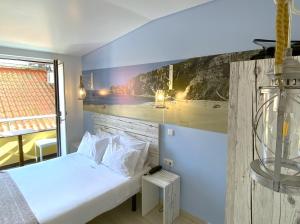 um quarto com uma cama e um quadro na parede em By the Beach em Nazaré