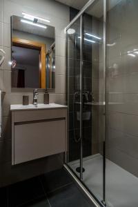a bathroom with a shower and a sink and a mirror at Casa das Ruas (Xisto Sentido®) 