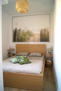 a bedroom with a bed with a picture on the wall at Apartament Garden AiR in Sztutowo