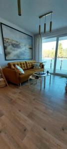 uma sala de estar com um sofá e uma mesa em Apartament Garden AiR em Sztutowo