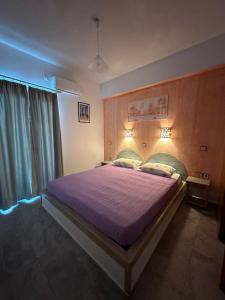 1 dormitorio con 1 cama grande con manta morada en Studios Matina en Naxos