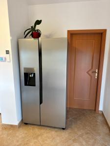 un frigorifero d'argento con una pianta in vaso sopra di Apartments Primani a Sečovlje
