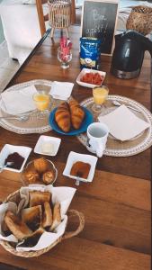 une table recouverte de assiettes de pain et de tasses de jus d'orange dans l'établissement Casa Ditta, à Mela