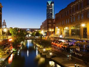 a river in a city at night with buildings at O-K-Sea - near Uptown 23 & Asian District in Oklahoma City