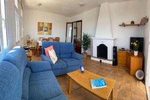 a living room with blue couches and a fireplace at Marina in Cala en Blanes