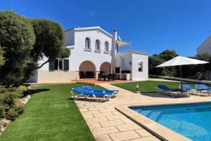 a villa with a swimming pool and a house at Marina in Cala en Blanes