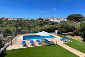 a villa with a swimming pool and lawn at Marina in Cala en Blanes
