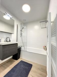 y baño con bañera, lavamanos y ducha. en Cosy Apartment Brussels - Avenue Louise, en Bruselas