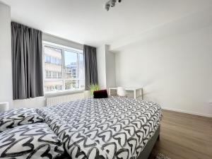 Cosy Apartment Brussels - Avenue Louise في بروكسل: غرفة نوم بسرير كبير ونافذة كبيرة