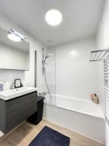 uma casa de banho com uma banheira, um lavatório e um chuveiro em Cosy Apartment Brussels - Avenue Louise em Bruxelas