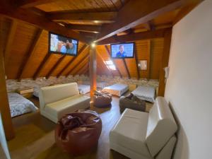 una sala de estar con 2 TV en una cabaña en Na Crista da Onda, en Nazaré