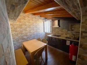 uma cozinha com uma mesa e uma parede de tijolos em Na Crista da Onda na Nazaré