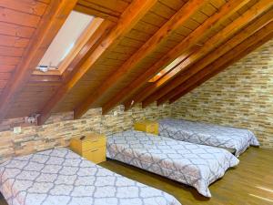 três camas num quarto com uma parede de tijolos em Na Crista da Onda na Nazaré