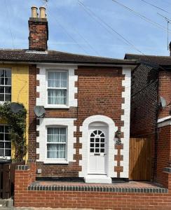 a red brick house with a white door at Cottage, 10 mins Train / River in Burnham-on-Crouch