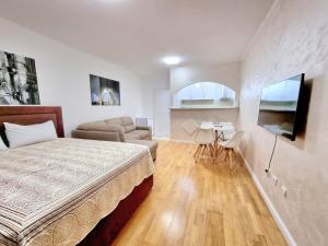 a bedroom with a bed and a living room at Becici Studio Apartment in Budva