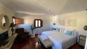 sypialnia z dużym białym łóżkiem i telewizorem w obiekcie La Posada de Chinchilla w mieście Chinchilla de Monte Aragón