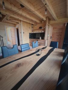 sala konferencyjna z dużym drewnianym stołem i niebieskimi krzesłami w obiekcie Bieszczadzki Zagajnik w mieście Lesko
