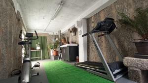 sala de fitness con cinta de correr y bicicleta estática en A Chainita, en Caldas de Reis