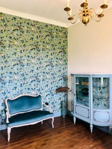 una silla en una habitación con papel pintado con motivos florales en Chateau de la Coutere en Saint-Laurent