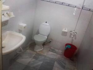 a bathroom with a white toilet and a sink at Siwakhat Huts in Shoghot
