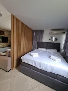 a bedroom with a large bed with white sheets at Villa with Pool & Garden apartment 1 Ognjen in Tivat