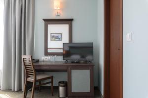 a desk with a television and a chair in a room at Lion Sunny Beach Hotel in Sunny Beach