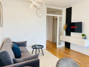 uma sala de estar com um sofá e uma mesa em KYANIT APARTMENT: FREE PARKING + POOL + NETFLIX em Wuppertal