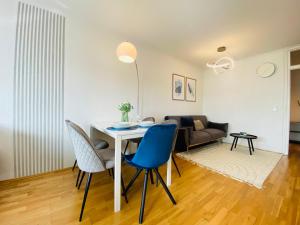 - un salon avec une table, des chaises et un canapé dans l'établissement KYANIT APARTMENT: FREE PARKING + POOL + NETFLIX, à Wuppertal