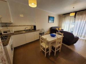 een keuken en een woonkamer met een tafel en een bank bij Magnifico apartamento en O Grove in O Grove