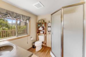 a bathroom with a shower and a toilet and a window at Beach Haven in Lincoln City