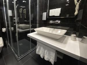 La salle de bains est pourvue d'un lavabo et d'une douche. dans l'établissement Hotel Oceano, à Nazaré