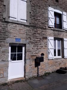 a brick building with a white door and windows at GITE ANNA in Le Châtelet-sur-Sormonne +3 photos