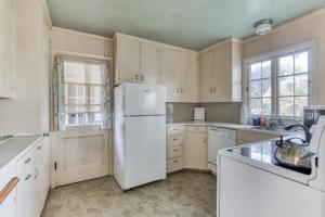 a kitchen with a white refrigerator and a sink at Seaside Governor's House Vacation Rental in Seaside