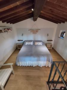 ein Schlafzimmer mit einem großen Bett in einem Zimmer mit Holzdecken in der Unterkunft Il Fienile tra gli Ulivi in Lamporecchio