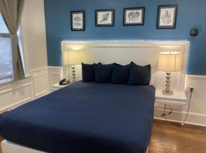 a blue bedroom with a large bed with two lamps at Long Beach Hotel in Long Beach