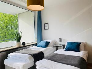 two beds in a room with a window at KYANIT APARTMENT: FREE PARKING + POOL + NETFLIX in Wuppertal
