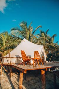 two chairs and a tent on the beach at GlampIKAL formerly Casa Nawal in Tulum