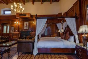a bedroom with a canopy bed and a living room at Cecil Murree in Murree