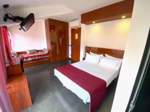 a bedroom with a large bed with a red blanket at Hotel Oceano in Nazaré