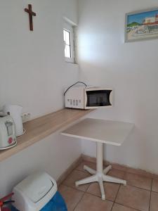 a white counter with a microwave on a table at Seaside Studios in Mesongi