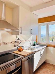 eine Küche mit einem Waschbecken und einem Fenster in der Unterkunft Artabra Infinita Petit Home in Ferrol