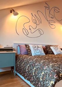 a bedroom with a bed with a writing on the wall at Artabra Infinita Petit Home in Ferrol