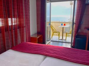 1 Schlafzimmer mit einem Bett und einem Balkon mit einem Tisch in der Unterkunft Hotel Oceano in Nazaré