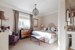 a bedroom with a bed and a purple chair at Victoria in Holkham
