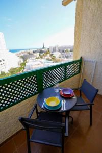 uma mesa e cadeiras numa varanda com vista em Stylish apartment with stunning sea view. em Maspalomas